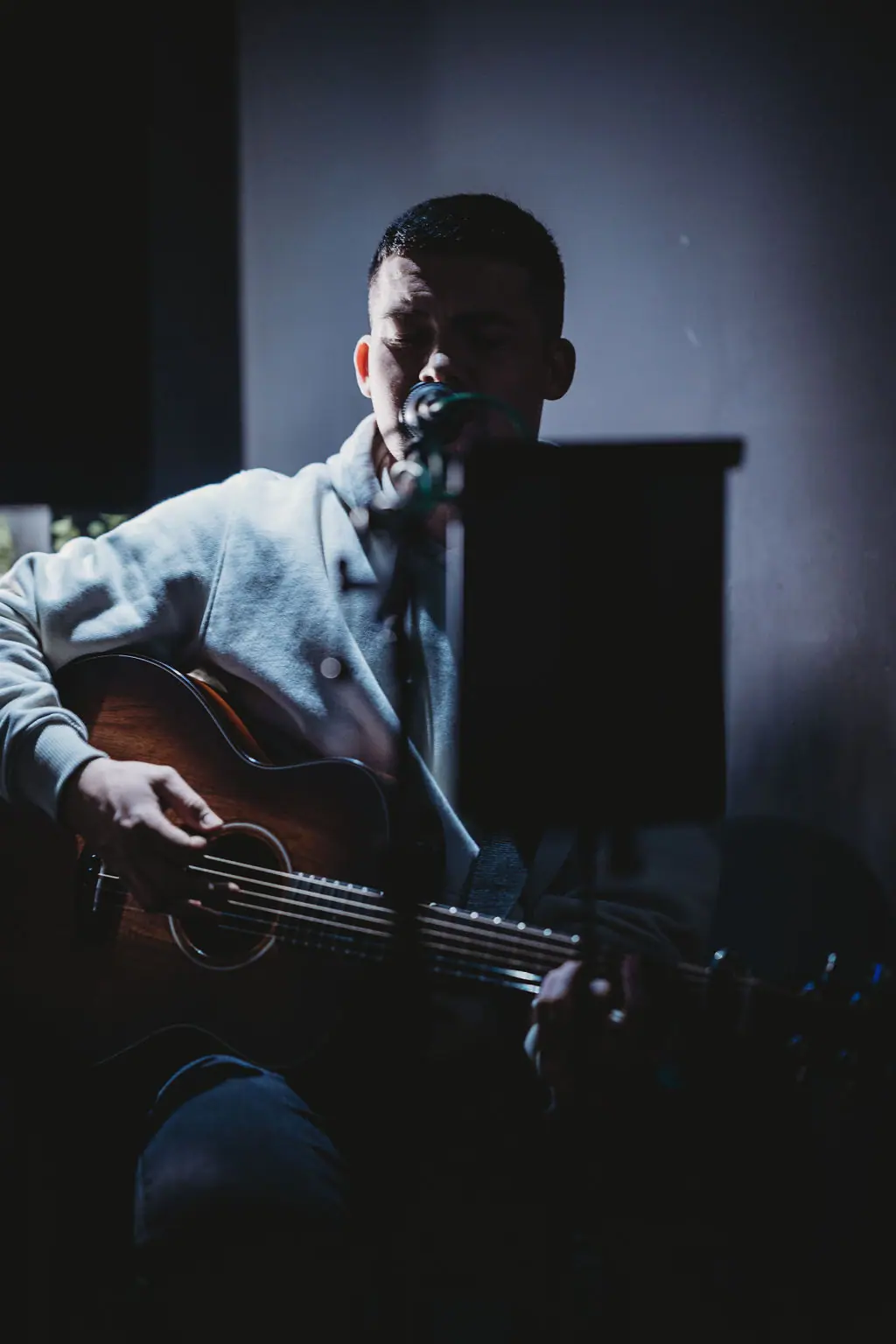 A singer with an acoustic guitar performing at The Teal Monkey