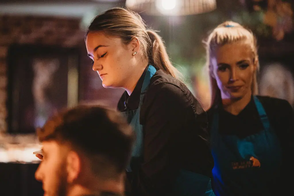 Two of the Teal Monkey team smiling during a busy service