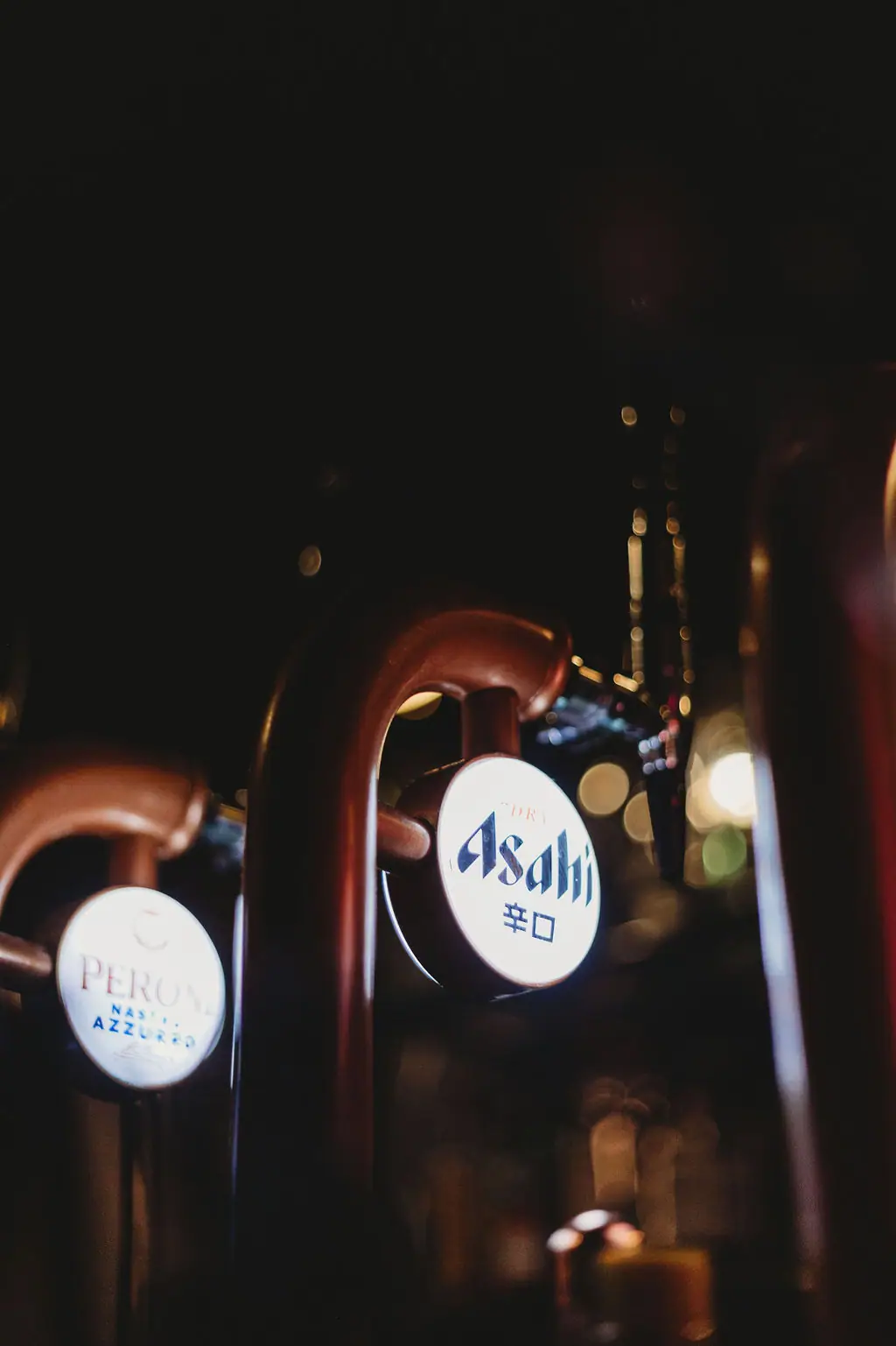 Illuminated Asahi and Peroni beer taps at the bar